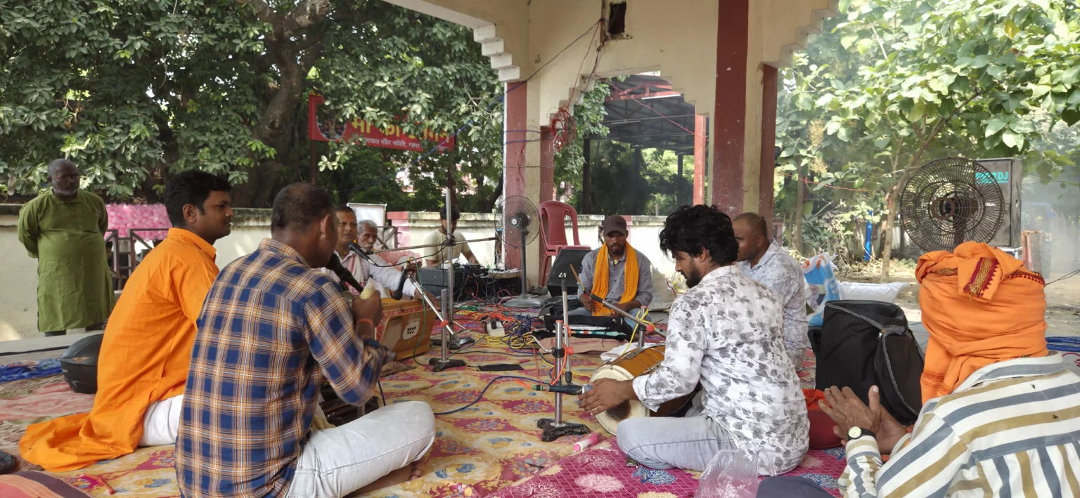 माँ कामाख्या धाम गहमर परिसर में हारमोनियम और ढोलक के साथ पारंपरिक भजन-कीर्तन गाते कलाकार।